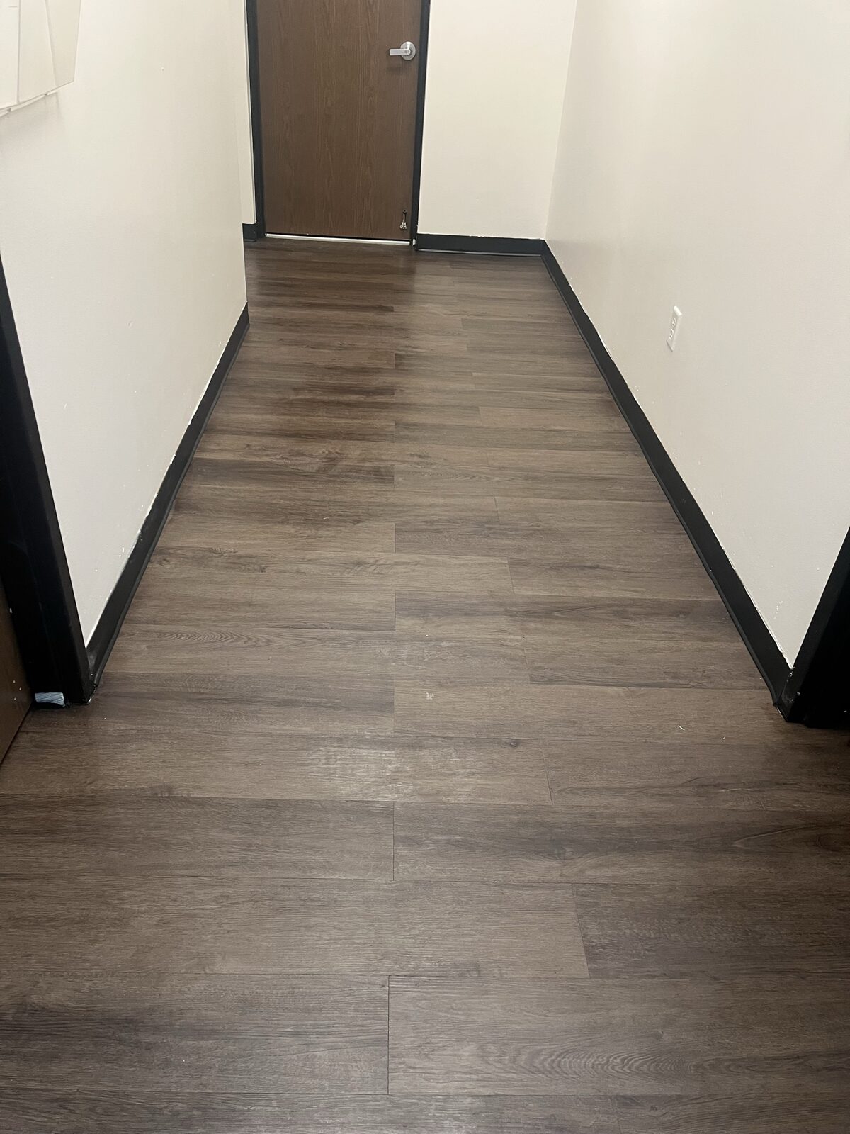 Commercial office corridor with luxury vinyl plank flooring installation