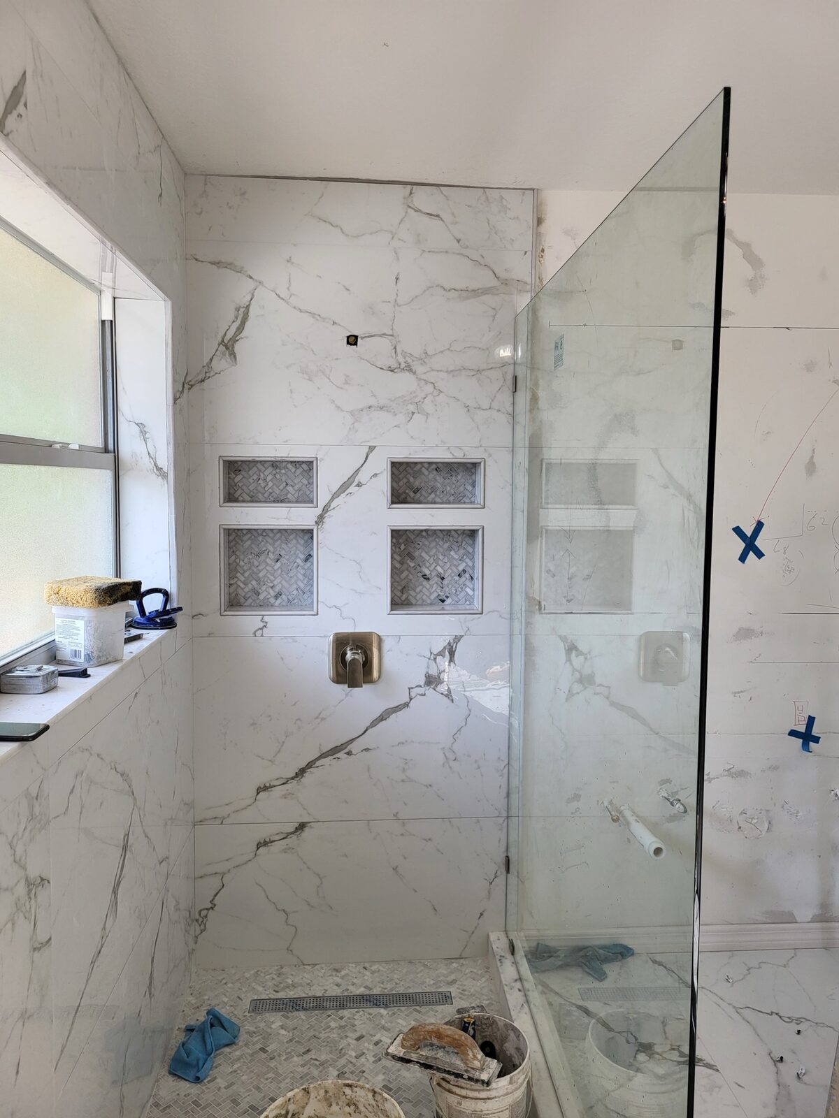 Custom shower with herringbone niche inserts and marble tile