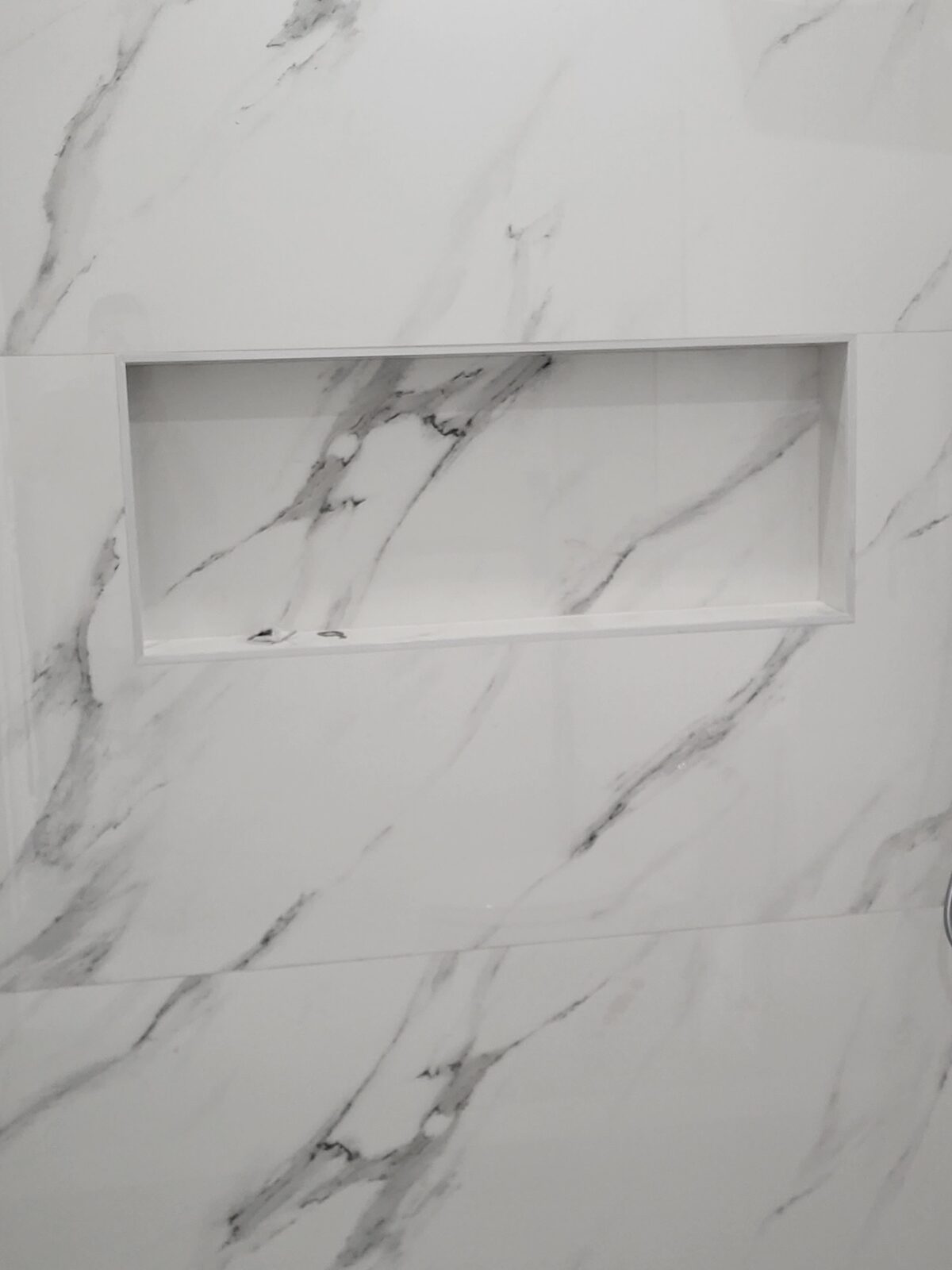 Shower wall niche detail with book-matched Calacatta marble tile