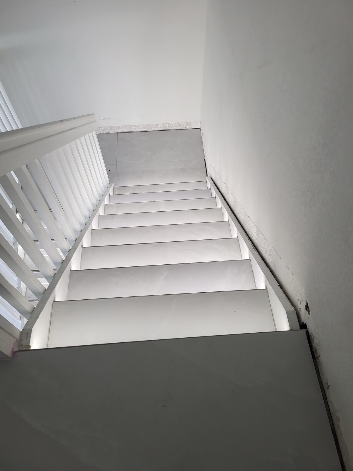Staircase renovation with marble tile treads and white painted risers
